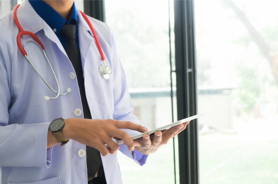 Healthcare professional holding a tablet.